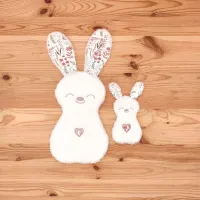 Le doudou d'aide à la séparation Florine la Lapine, avec ses oreilles fleuries pour accompagner maman et bébé lorsqu'ils ne sont pas ensemble