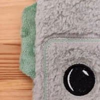 Gros plan sur Tibo le Robot, un doudou doux et sensoriel. Idéal pour apaiser bébé avec l’odeur des parents grâce à ses coussinets parfumés.