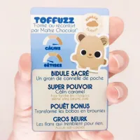 Carte collector Toffuzz dans la main – fiche de pouvoirs du doudou magique