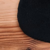 Gros plan sur le minky noir du doudou Bee Doux Salema le Chat