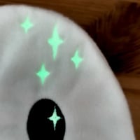 Gros plan sur les étoiles du doudou d'aide à la séparation Côme le Fantôme qui brillent dans le noir- Atelier Bombus