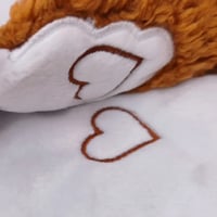 Les deux cœurs du doudou d'aide à la séparation Grégoire le Renard se fixent ensemble grâce à un système d'aimants scellés à l'intérieur des doudous