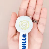 Détail de la spirale jaune brodée sur la tête minky céladon du marque-page Nebulo