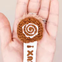 Gros plan sur la tête du marque-page Toffuzz – spirale brodée sur tricot chocolat